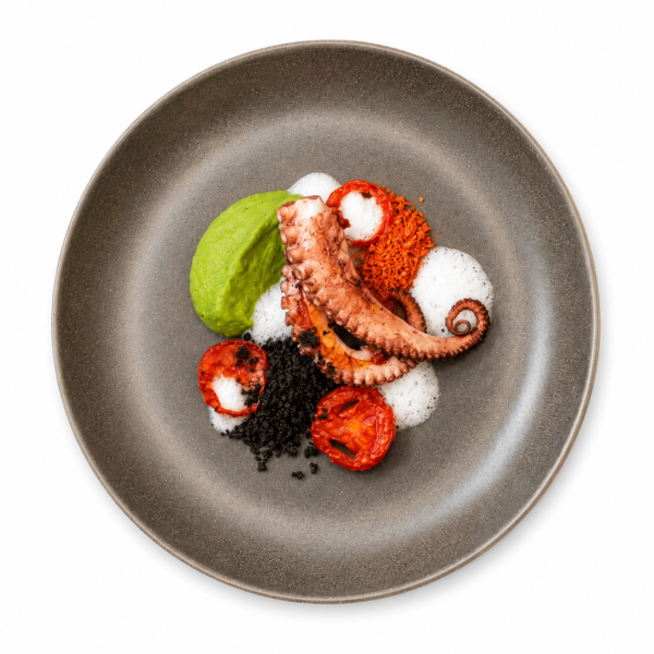 Roasted octopus with pea cream, oven-roasted tomatoes, and olive powder